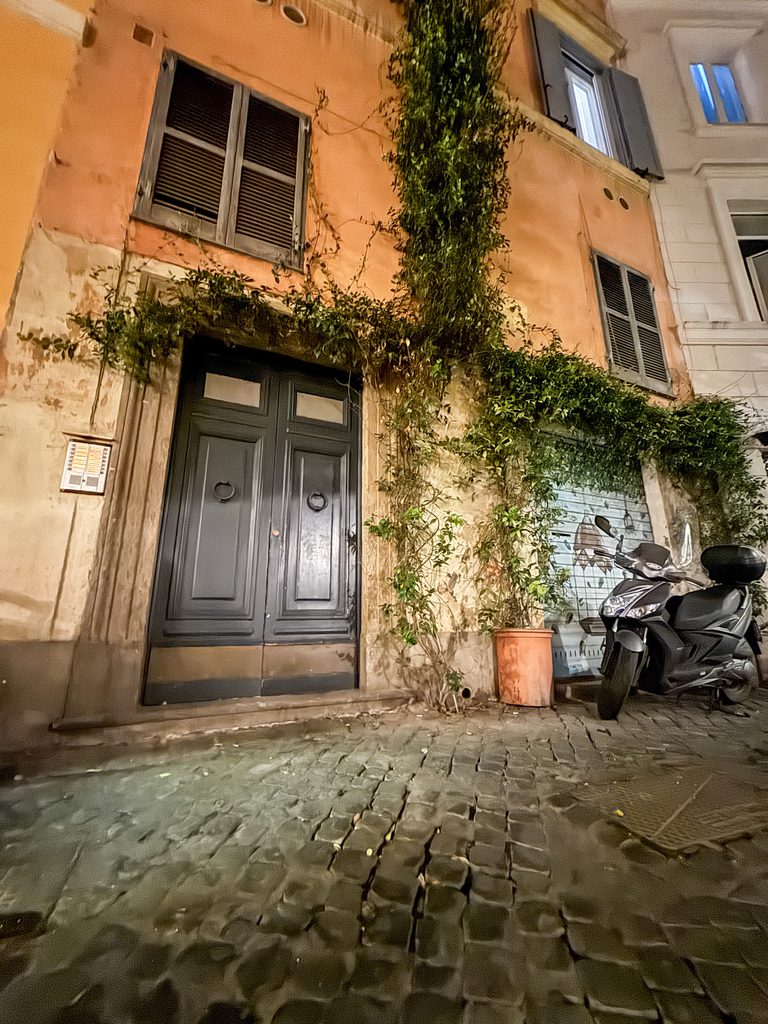 Ivy-covered doorway on a cobblestone street in Rome, Italy