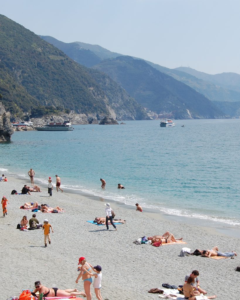 Travelers relaxing on a beach along the Italian coast