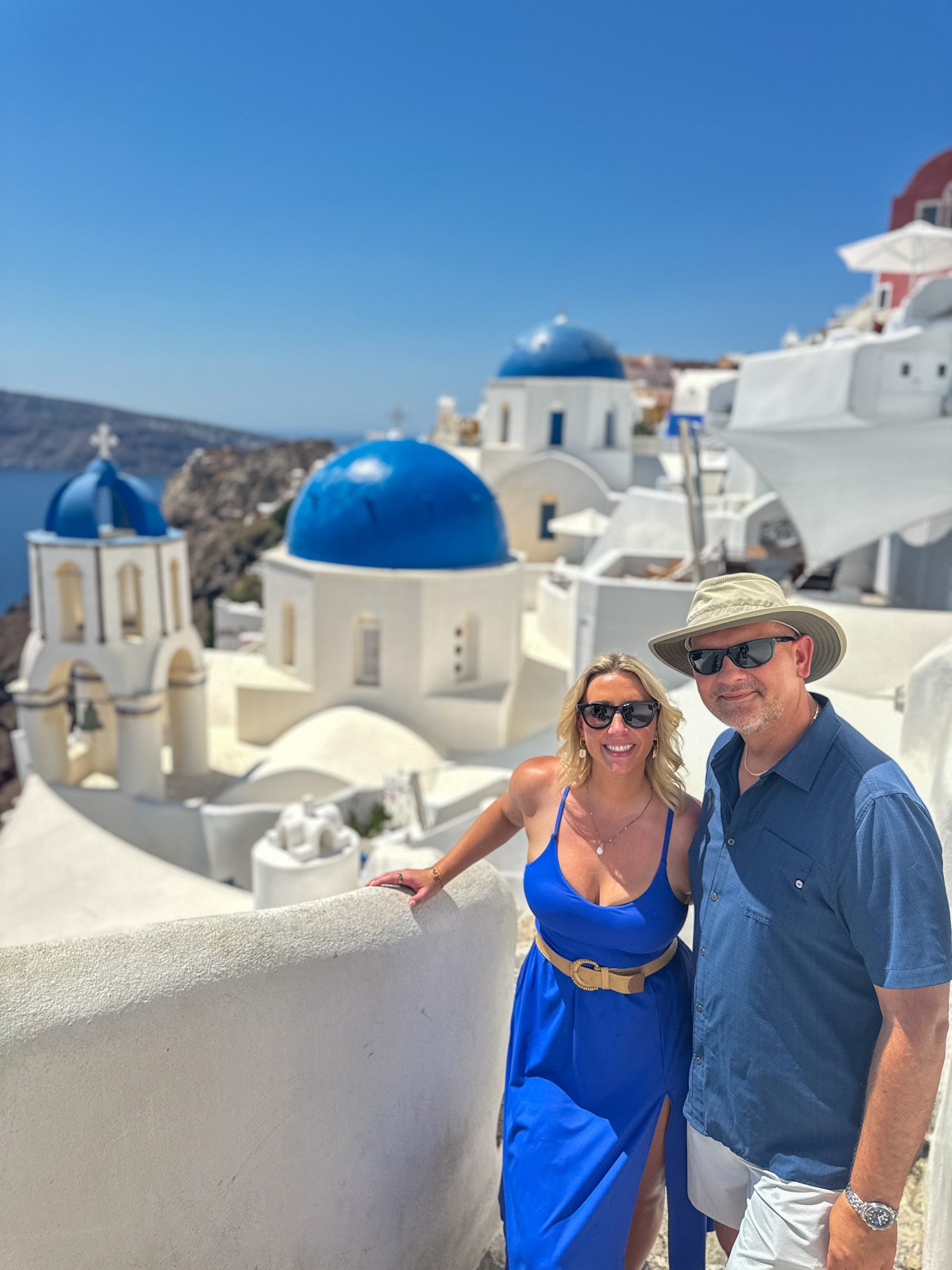 Couple on their honeymoon in Santorini, Greece, overlooking the iconic blue-domed churches