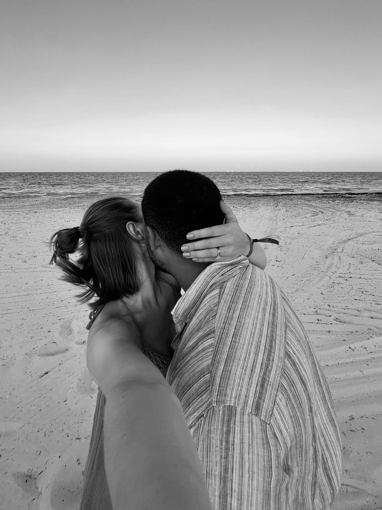 Newlywed couple kissing on a beach during their honeymoon